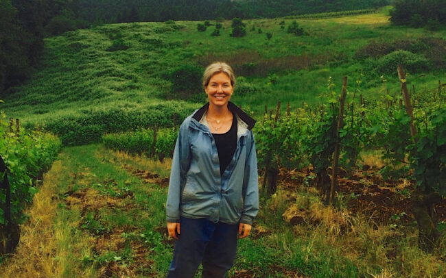 Kelley Fox standing in the Maresh Vineyard in Oregon Willamette Valley